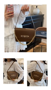 Détail d'un sac à main en cuir marron foncé avec fermoir doré et bandoulière chaîne
