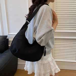 Large black nylon crescent crossbody bag with adjustable strap and minimalist drape