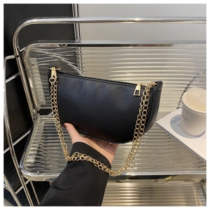 Nahaufnahme der schwarzen Unterachseltasche aus Leder mit eleganten goldenen Kettenriemen