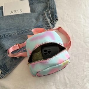 Detailed interior storage showing a mini tie-dye backpack holding a phone and umbrella