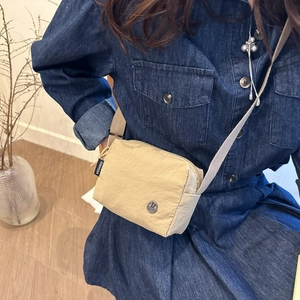 Stylish beige nylon crossbody bag with pleated texture and adjustable strap for women