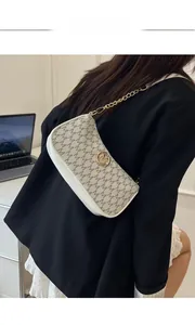 Detail of white monogram shoulder bag with gold chain strap and metal logo