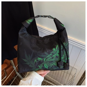Close-up of Xiangyun silk crescent bag with green leaf pattern and buckle strap detail