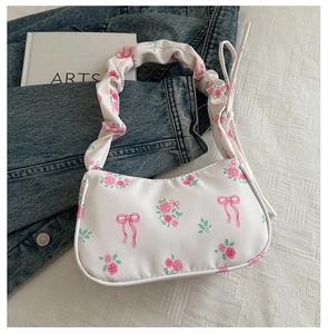 Détail du sac sous l'aisselle à imprimé floral avec roses et poignée à volants