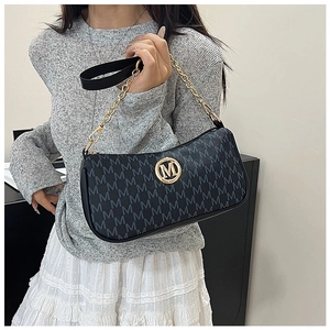 Detail of black crescent bag with letter print and gold metal logo emblem