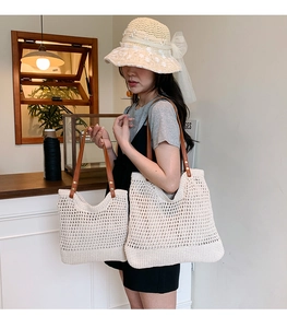 Dettaglio della borsa tote beige tessuta a mano con manici in pelle marrone in un caffè