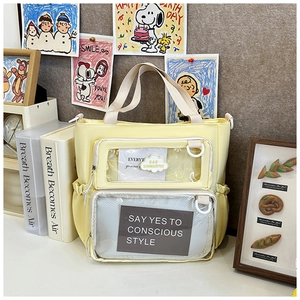 Detail of light yellow canvas tote bag with clear PVC pockets and decorative cards
