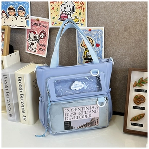 Detail view of light blue ita bag featuring transparent display window and mesh pocket storage