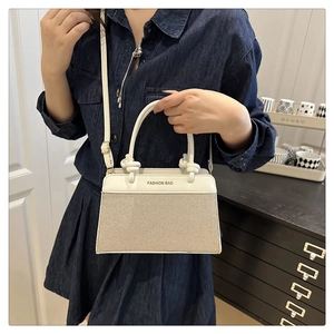 Detail of minimalist woven handbag with white PU leather knot handle and shoulder strap