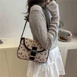 Vintage cherry print shoulder bag with black leather straps and large gold metal buckle