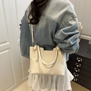 Elegant off-white lychee leather handbag for women featuring a minimalist bucket design