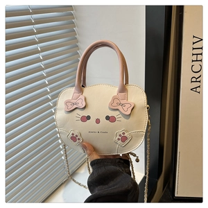 Detalle de bolso de gato con lazo rosa, logotipo de marca y correa de cadena metálica