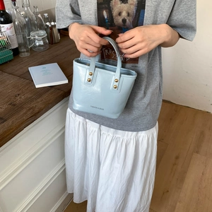 Fashionable light blue mini tote bag in oil wax leather with gold studs and top handle