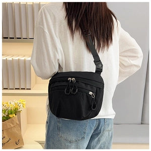 Detailed back view of casual black checkered nylon crossbody bag worn by a model