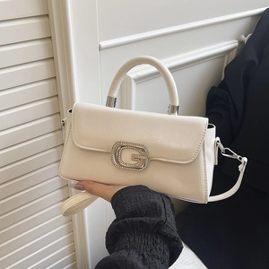 Detail showing the cream handbag with textured synthetic leather and a metal G buckle