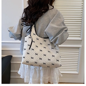 Close-up of sweet bow and polka dot pattern on canvas shoulder bag with ribbon detail