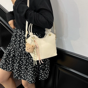 Sac seau minimaliste en cuir beige avec breloque ours en peluche pour le quotidien
