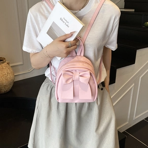 Chic pink mini backpack for women featuring a large bow and premium leather finish