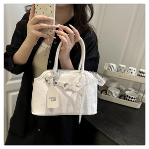 Détail d'un sac à main blanc rétro avec un nœud en dentelle et poignée chic