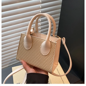 Detail of vintage beige straw woven crossbody bag with premium leather stitching and handle
