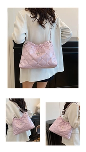 Détail du sac cabas en cuir verni rose avec rivets en étoile et bandoulière chaîne