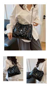 Détail du sac cabas en cuir matelassé noir avec rivets argentés et ornement en étoile