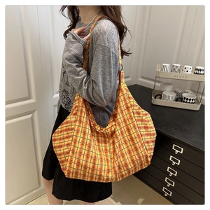 Detail view of the large capacity yellow plaid canvas tote bag with metal ring strap connector