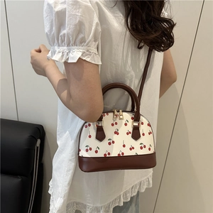 White cherry print shell handbag with dark brown leather straps and gold hardware