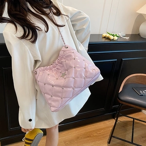 Sac rose matelassé à chaîne avec strass et étoile argentée porté par un mannequin