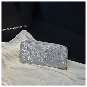 Silver snakeskin long wallet with gold zippers on silk fabric for gift presentation