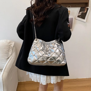 Sac fourre-tout argenté matelassé avec étoile et chaîne porté par un mannequin