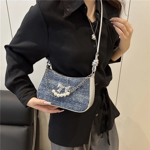 Denim crossbody bag with silver butterfly bow and pearl chain shown on model