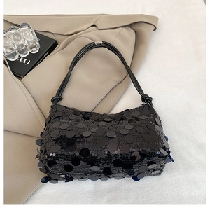 Detail of black sequin baguette bag with knotted handle and silver metal clasp closure