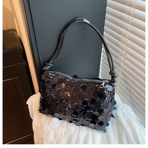 Detail of a chic black sequin shoulder bag with round scales and woven rope handle