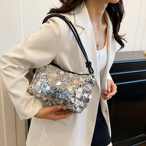 Fashionable silver sequin shoulder bag for women with black leather strap on a model