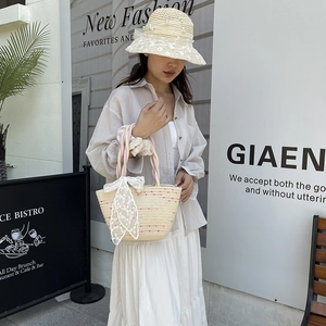 Handmade woven bucket bag with red dots and lace bow, styled with matching straw hat