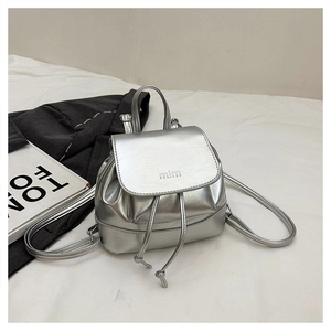 Detail of silver metallic PU backpack featuring a drawstring closure and debossed mim logo