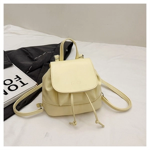 Detail of cream yellow mini backpack featuring drawstring closure and embossed mim logo