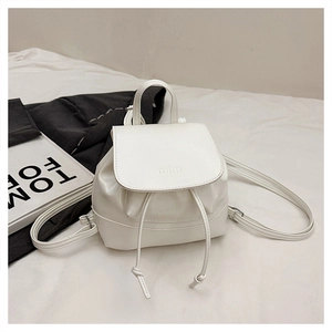 Close-up of white drawstring backpack featuring embossed mim logo and tom ford magazine