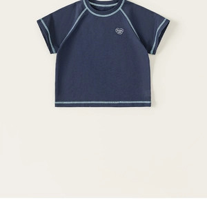 Detail view of navy blue T-shirt featuring contrast stitching and That's OK heart print