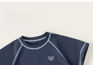 Close-up of contrast blue stitching and heart graphic on navy kids cotton T-shirt