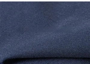Detailed close-up of navy blue knitted cotton fabric showing soft texture and fine weave