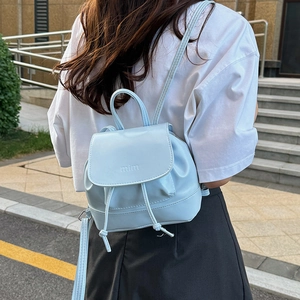Minimalist light blue drawstring mini backpack for women in a stylish outdoor street shot