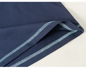 Close-up of precise double-needle hem stitching on dark blue cotton t-shirt fabric