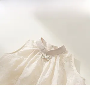 Détail de l'encolure robe qipao enfant avec nœud en perles et motif floral dentelle