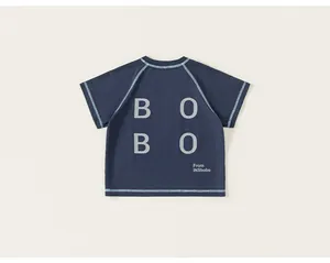 Detail of dark blue children shirt featuring contrast stitching and BOBO back print