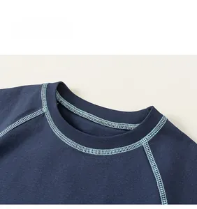 Close-up of dark blue kid T-shirt neckline with light blue contrast stitching details