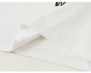 Detailed macro view showing the double-needle stitching on the white cotton t-shirt hem