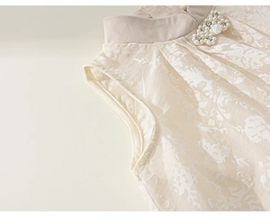 Détail du col montant avec nœud en perles et texture jacquard sur robe pour fille