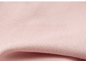 Gros plan sur la texture du tissu en maille côtelée rose montrant des rayures verticales